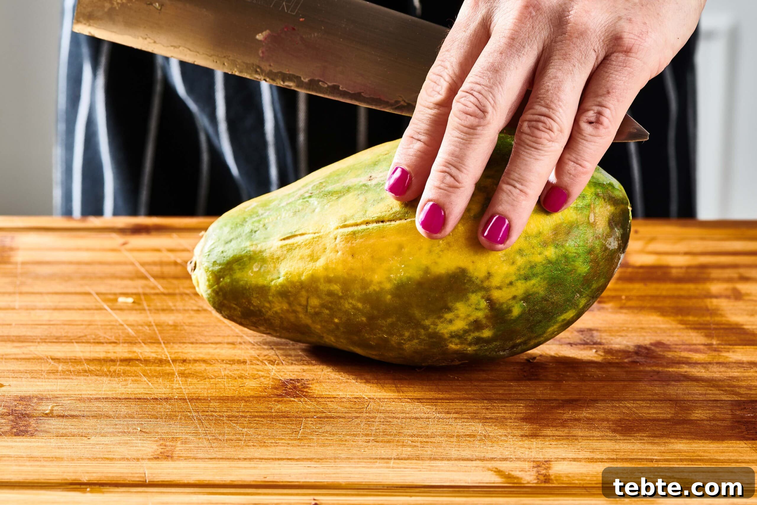 How to Slice and Prepare a Papaya Quickly 4 Woman holding a papaya and a large knife.