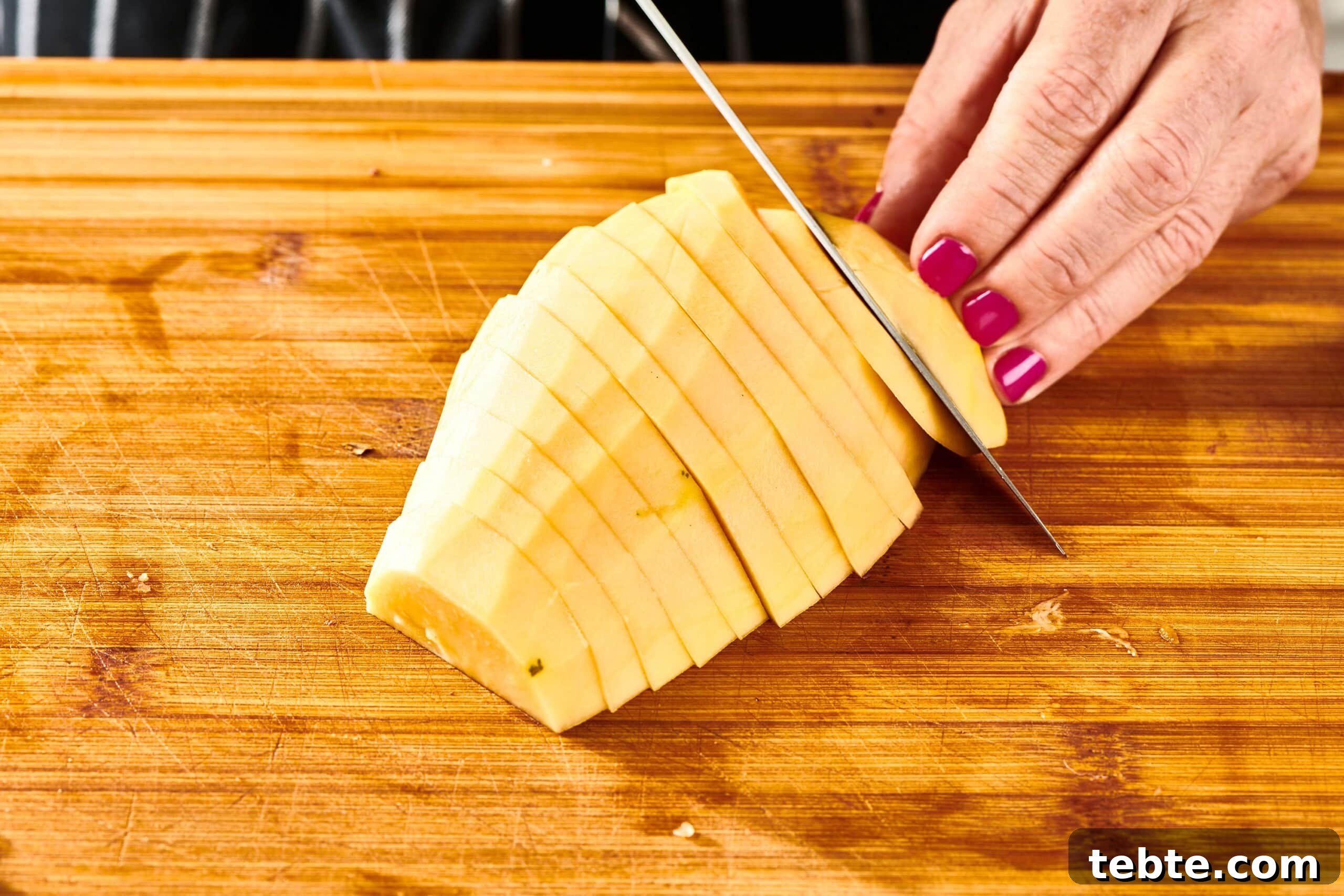 How to Slice and Prepare a Papaya Quickly 7 Woman slicing a halved, peeled papaya.