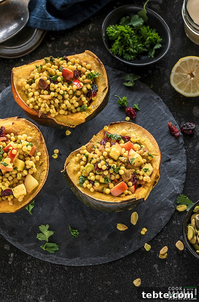Israeli Couscous-Stuffed Acorn Squash with Herbs and Feta 5 three halves of stuffed acorn squash on a black round board