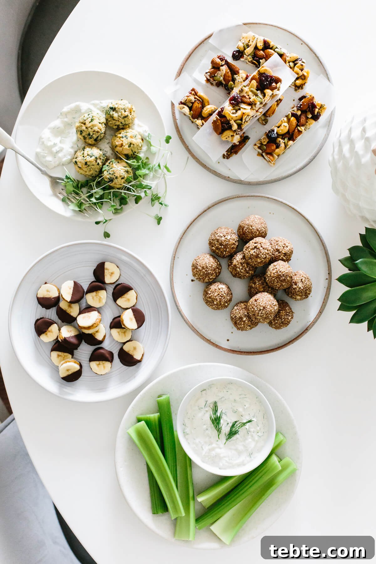 Several healthy snacks and ideas on separate plates on a table.