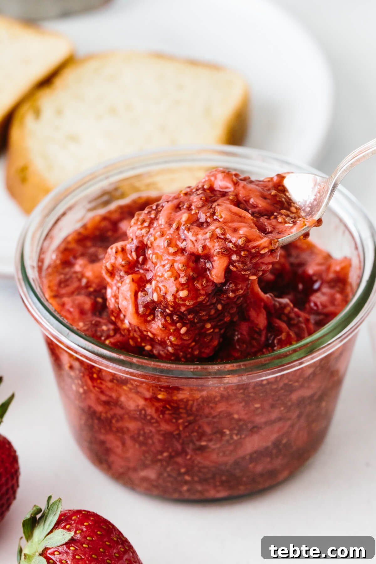 A spoonful of chia seed jam with toast in the background.