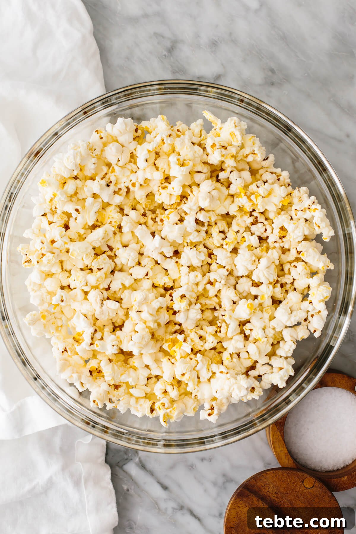 Microwave popcorn in a glass bowl on a table.