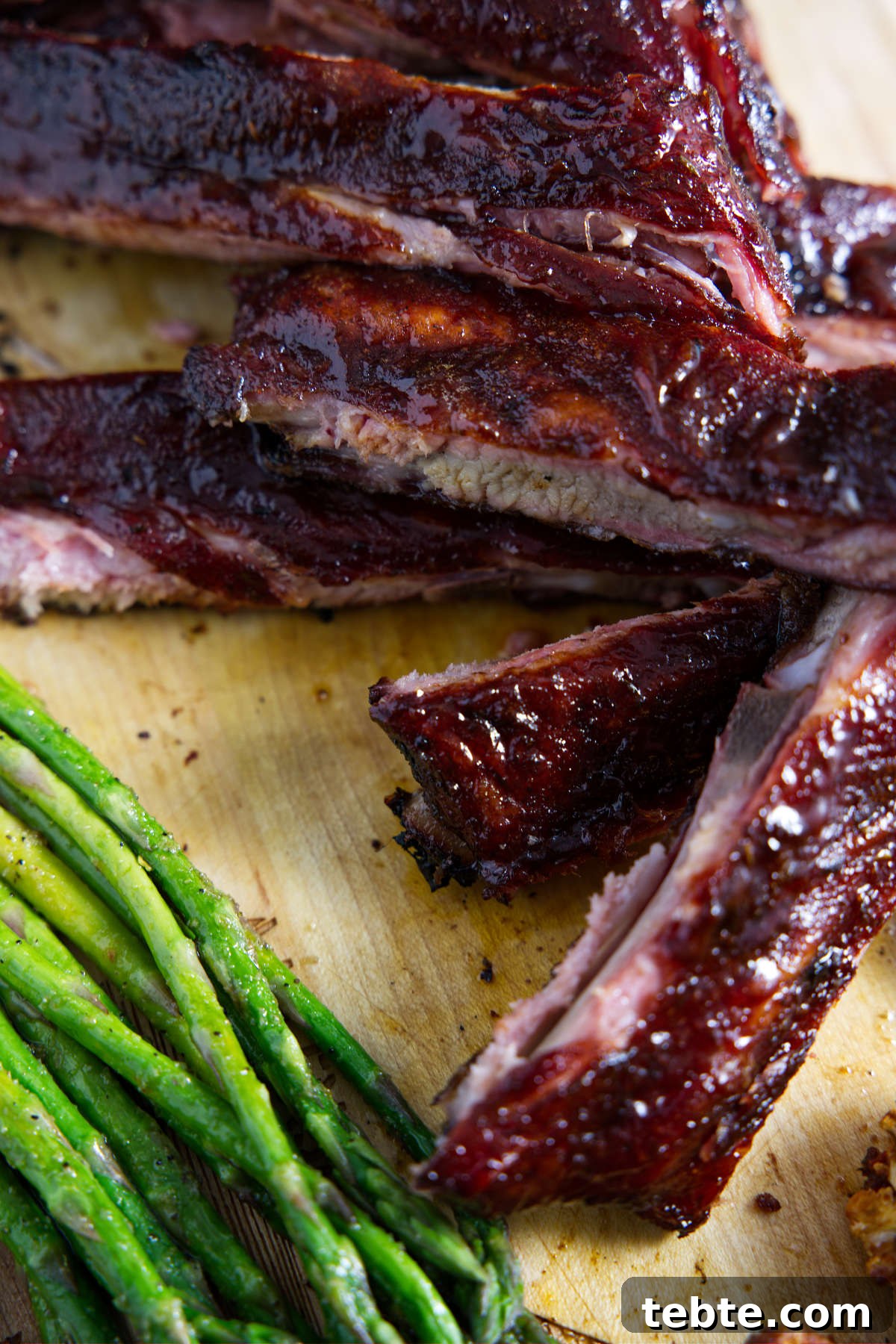 3-2-1 Smoked Ribs Recipe: Perfect Tender Fall-Off-the-Bone Ribs 9 sliced traeger 3-2-1 ribs on cutting board with asparagus