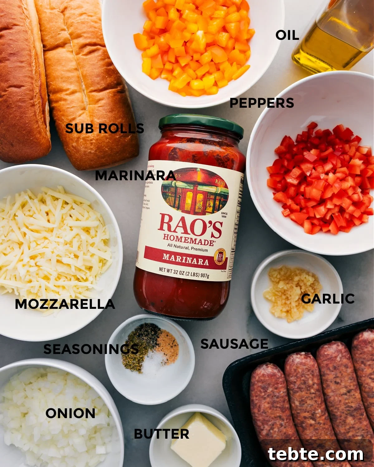 Ingredients In Italian Sausage Sandwich All the ingredients for this recipe are prepped and ready for easy assembly, including peppers, rolls, marinara, mozzarella, onion, seasonings, sausage, garlic, and butter.