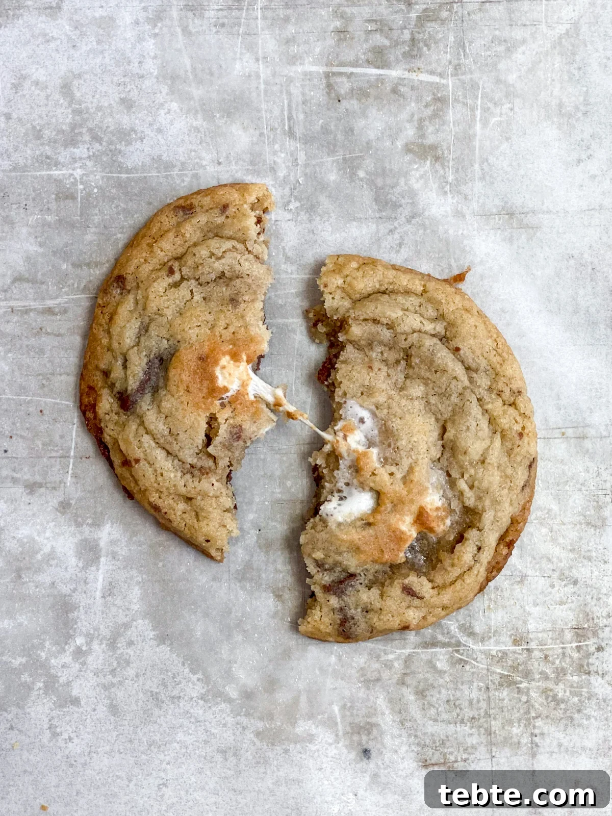 Chewy Chocolate Chip Cookies with Gooey Marshmallow Filling 2 chocolate chip marshmallow cookies split in half to see the marshmallow.