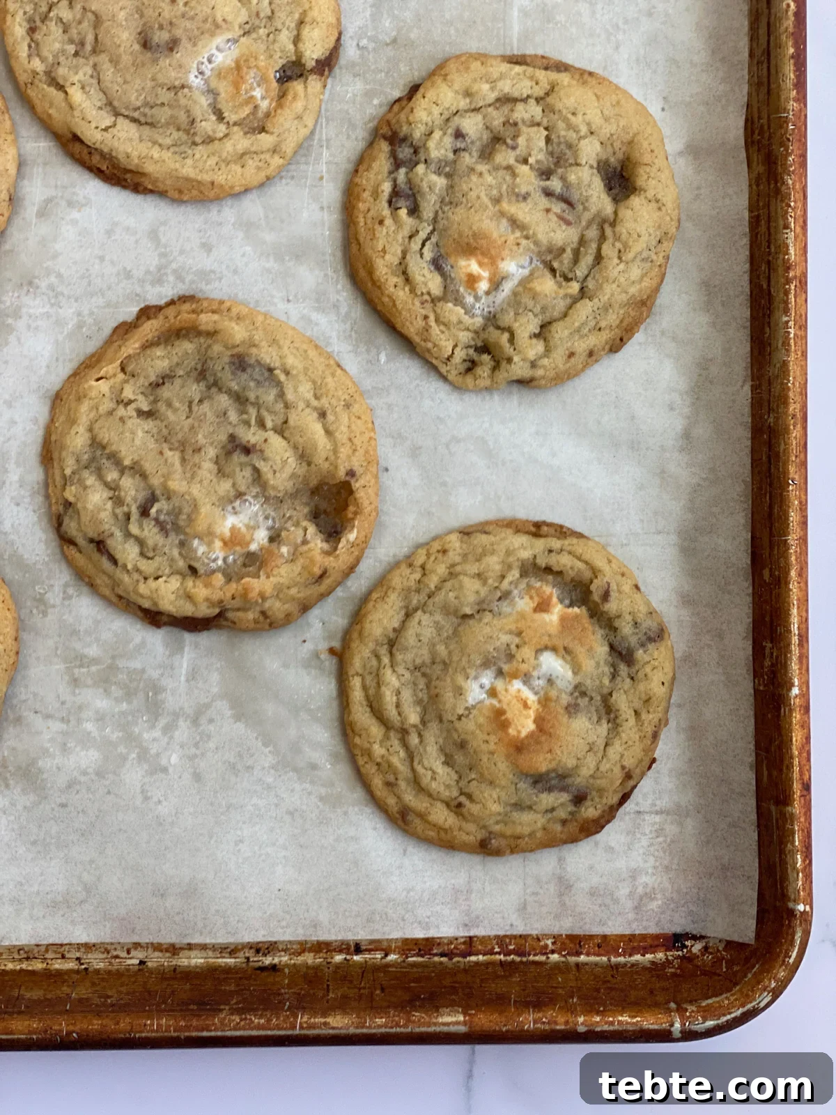 Chewy Chocolate Chip Cookies with Gooey Marshmallow Filling 3 close up of chocolate chip marshmallow cookies on baking sheet.