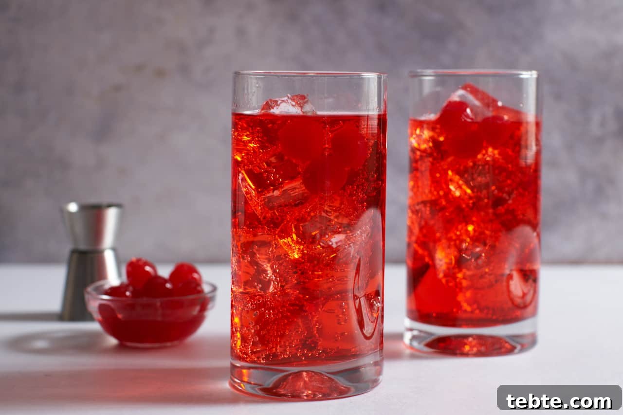 Dirty Shirley Cocktail Recipe: Spiked Shirley Temple Guide 4 Two Dirty Shirley cocktails in tall drink glasses garnished with maraschino cherries.