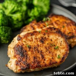 Hawaiian-Style Grilled Pork Chops with Pineapple Glaze 11 Two pieces of pork chops on a plate with broccoli.