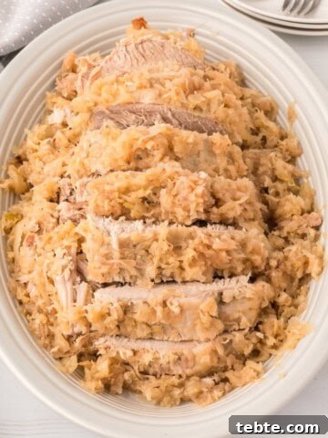 A plate of cooked roast pork and sauerkraut.