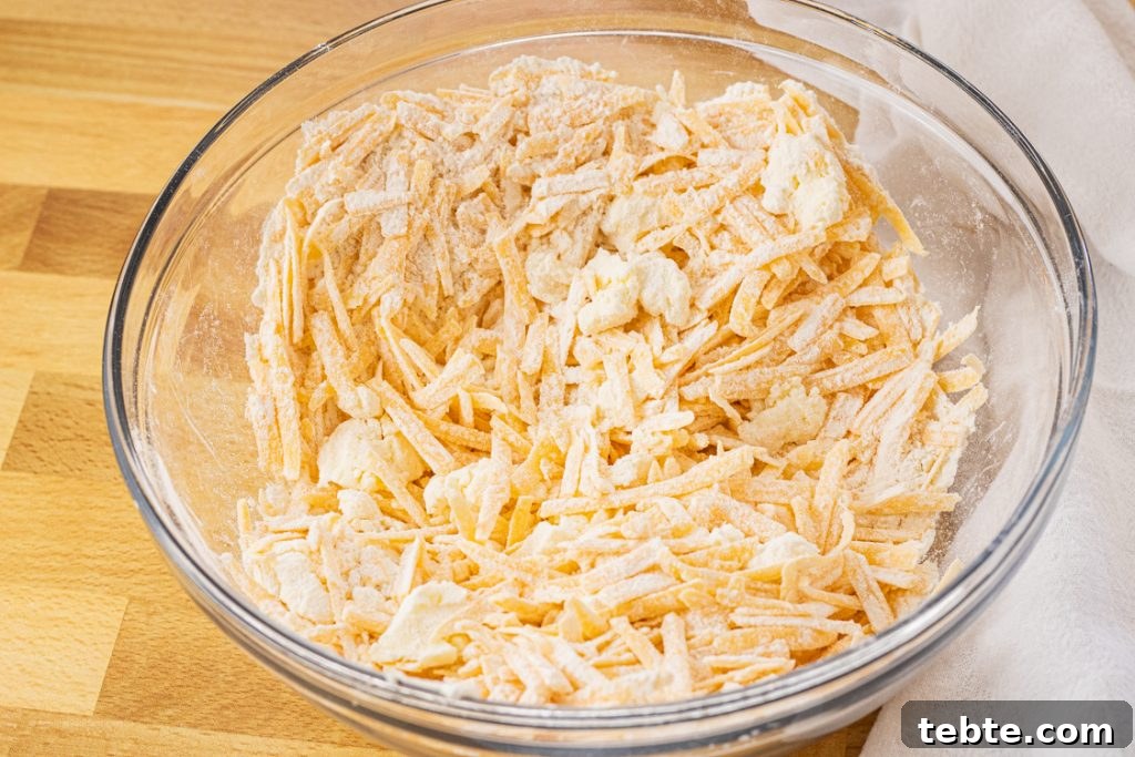 Crispy Homemade Cheese Crackers Recipe for Snack Lovers 3 cheese and butter covered in flour in a mixing bowl