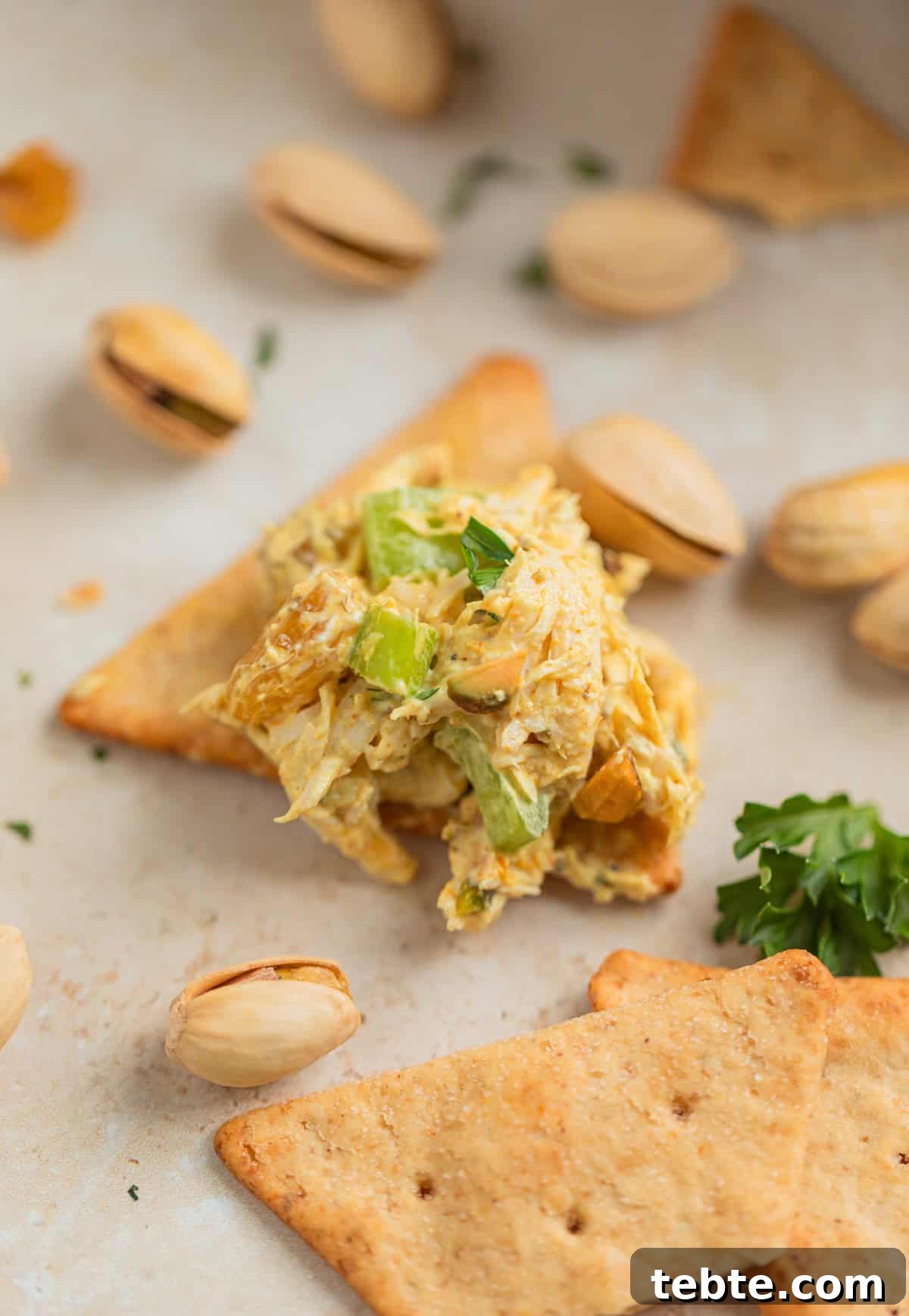 Creamy Curry Chicken Salad Recipe with Crunchy Apples and Almonds 6 Curry chicken salad served on cracker topped with parsley.