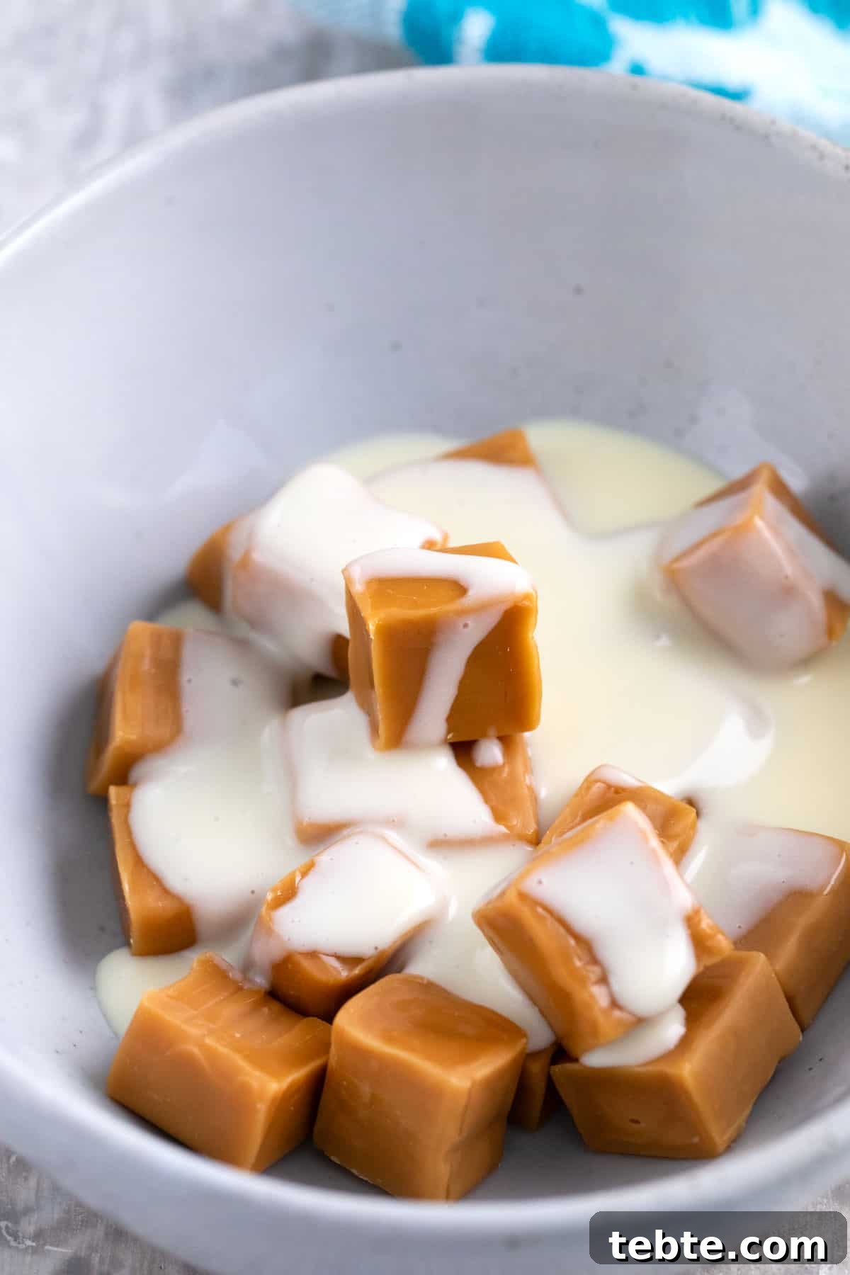 carmel candies and evaporated milk in a bowl for melting.