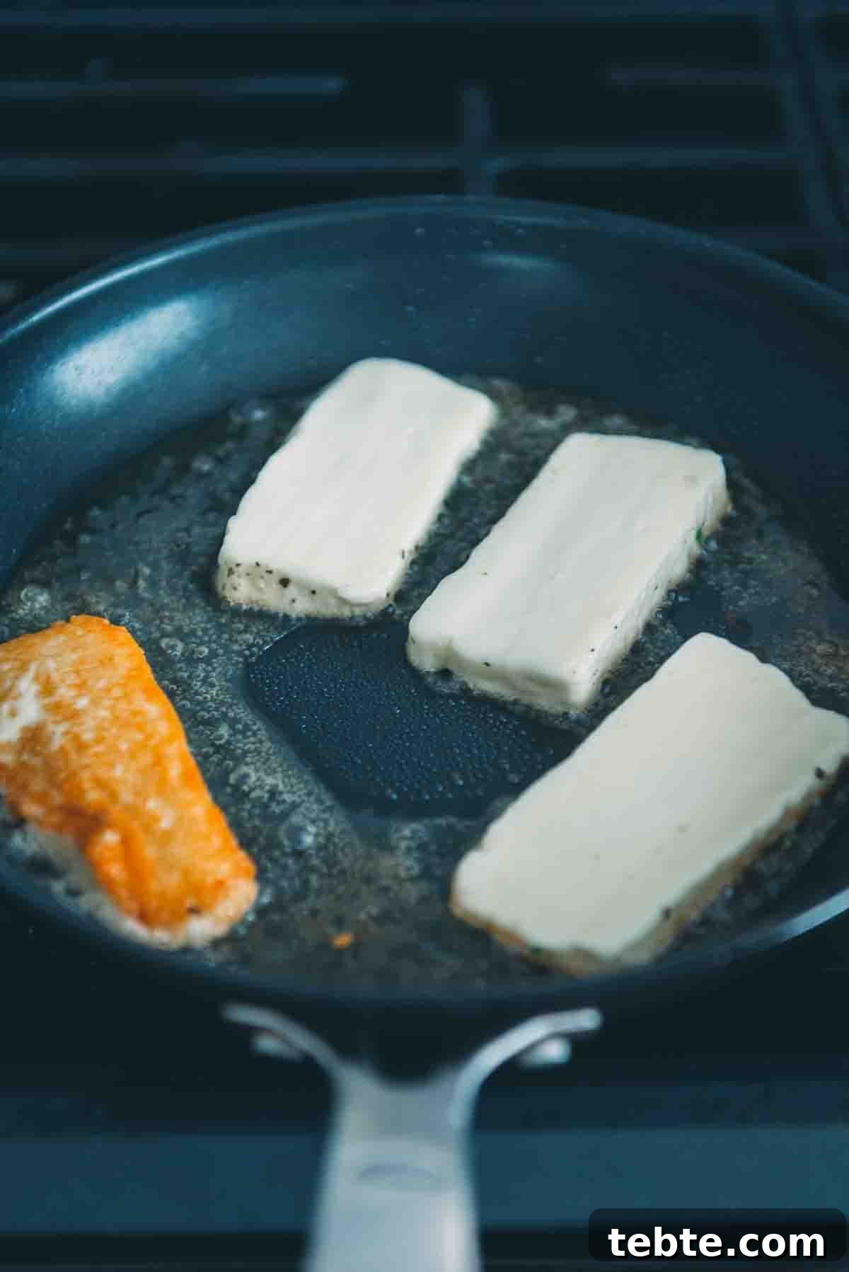Crispy Halloumi Shrimp Saganaki with Tomato and Feta 9 Cheese in a frying pan.