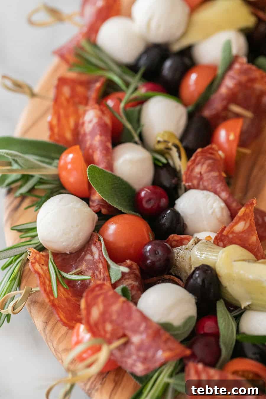 Antipasto skewers with cheese, olive, fresh sage and tomatoes.