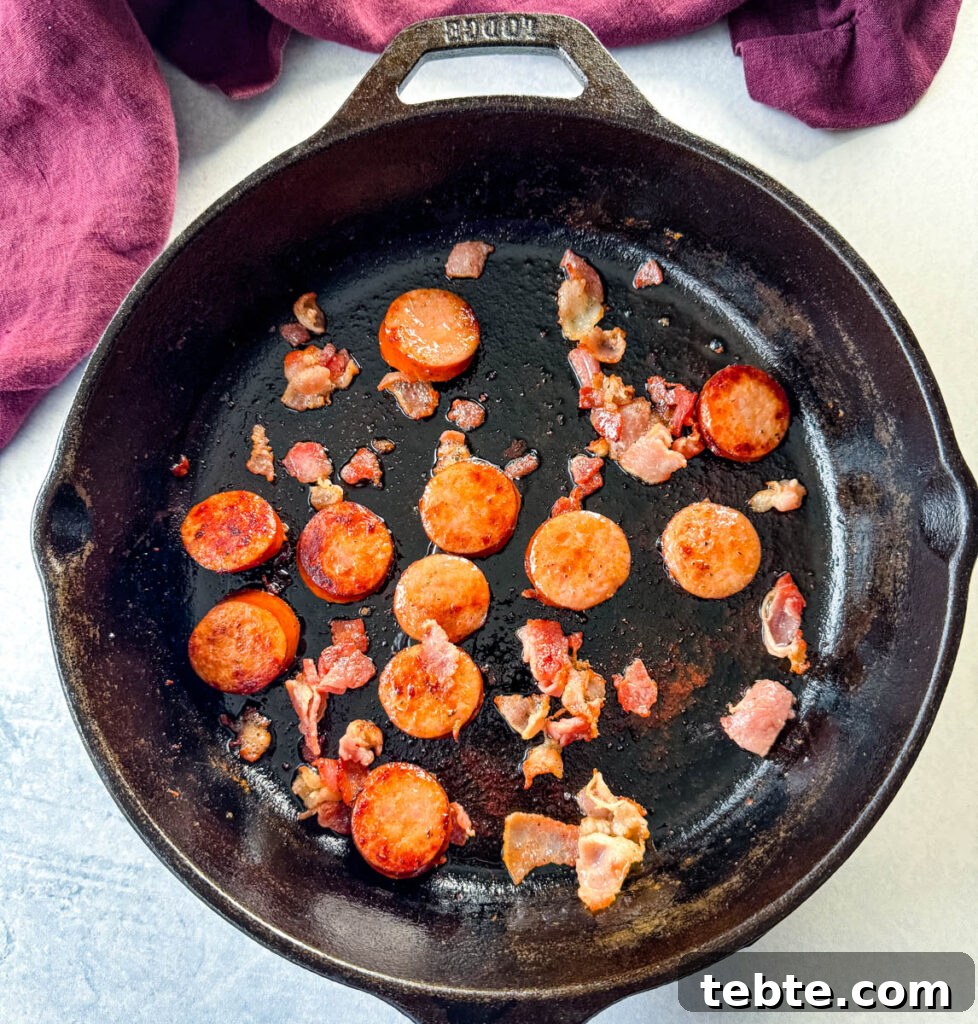 Classic Homemade Pork and Beans Recipe for Comforting Meals 7 cooked sausage and bacon in a cast iron skillet