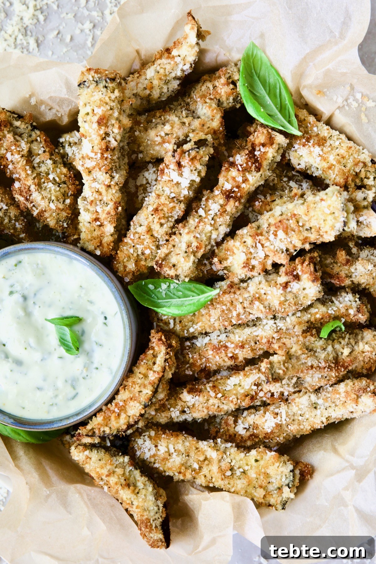 Crispy Air Fryer Eggplant Fries with Garlic Parmesan Dip 16 Air Fryer Eggplant Fries with Garlic Basil Aioli garnished with fresh basil.
