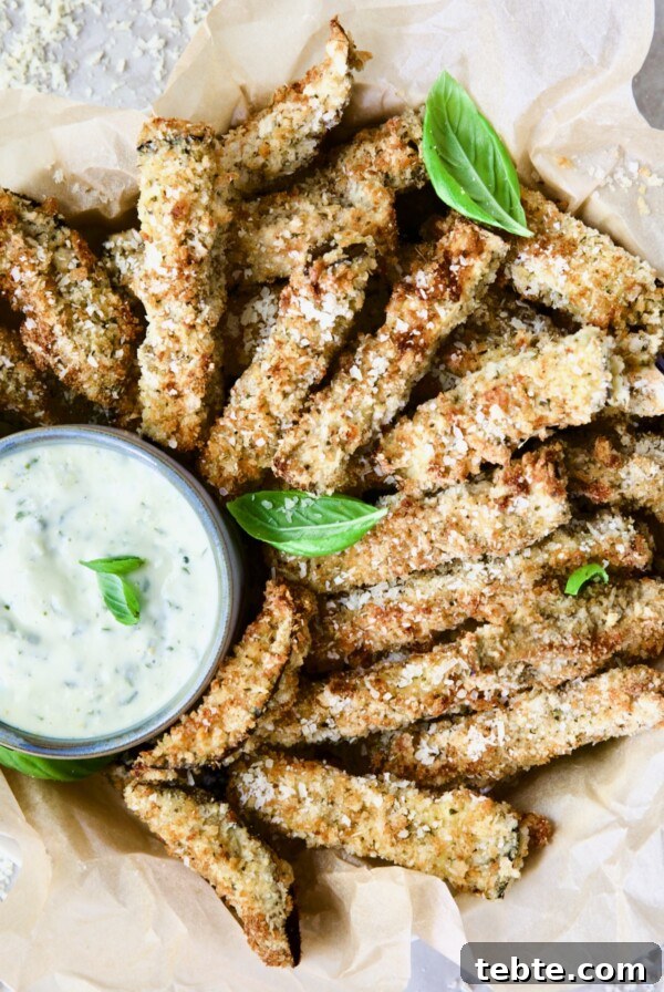 Crispy Air Fryer Eggplant Fries with Garlic Parmesan Dip 20 Air Fryer Eggplant Fries with Garlic Basil Aioli garnished with fresh basil.
