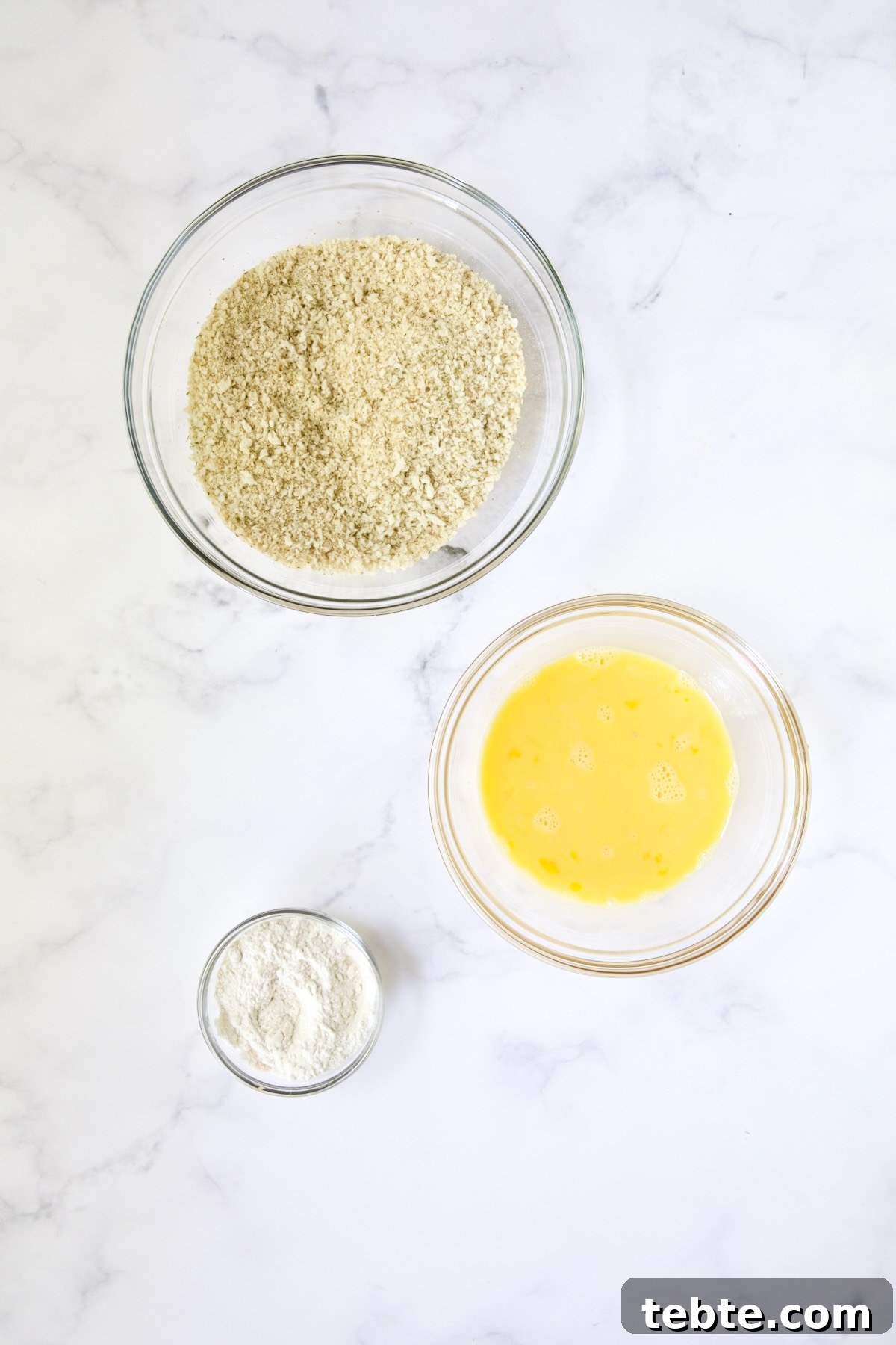 Crispy Air Fryer Eggplant Fries with Garlic Parmesan Dip 6 Three glass bowls: One consisting of breadcrumb blend, beaten eggs and all-purpose flour.