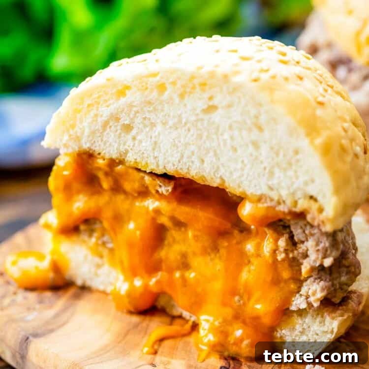 Juicy Lucy burger cut in half on a wood plank