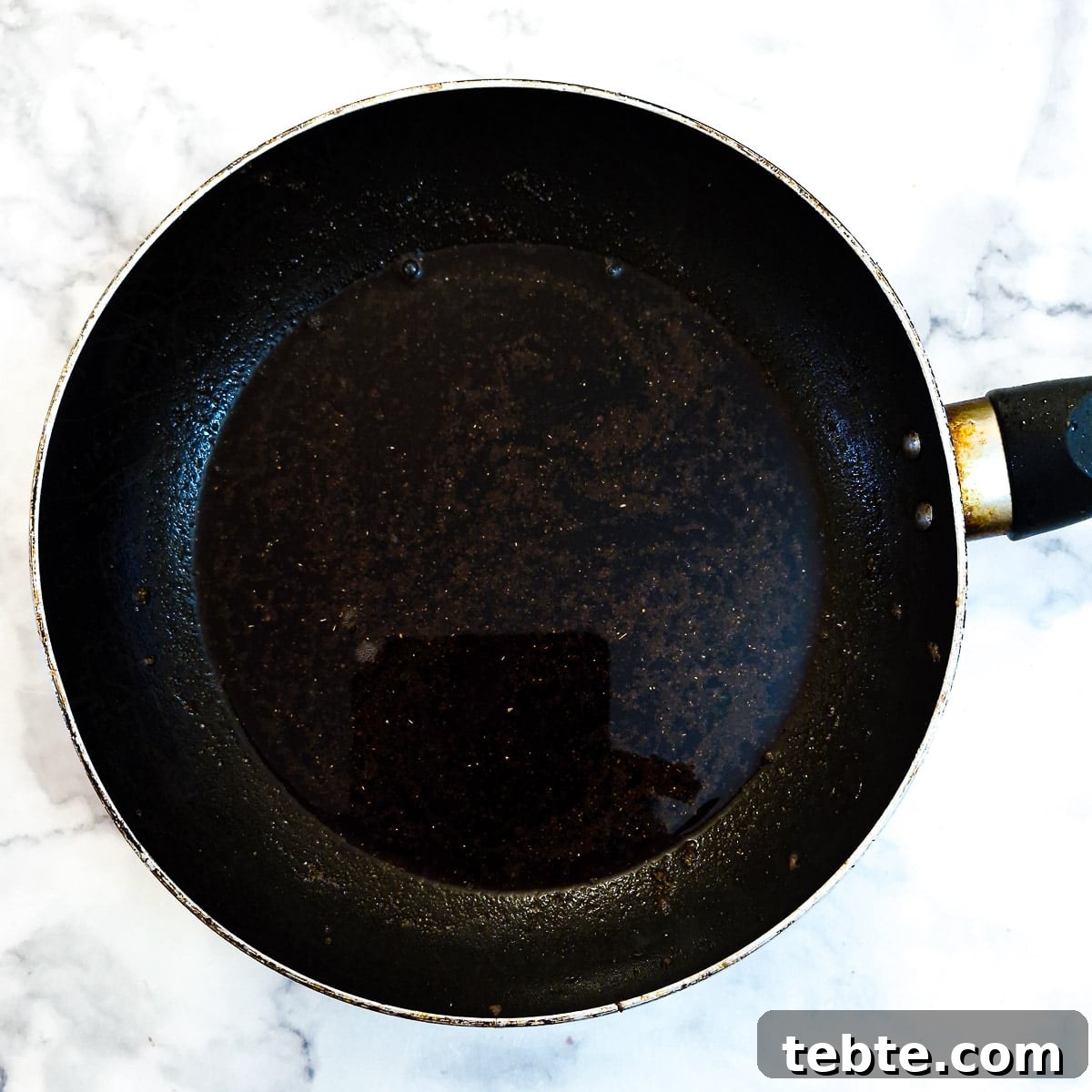 Spices and red wine in a frying pan.