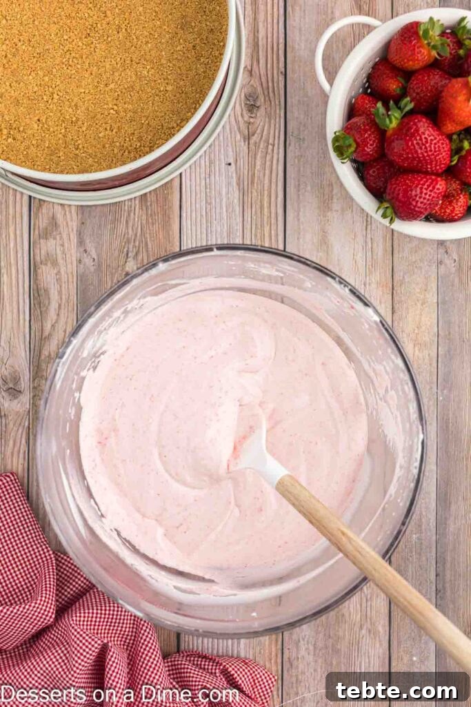 Creamy No-Bake Strawberry Cheesecake Recipe 8 Mixing strawberry puree into the cream cheese mixture
