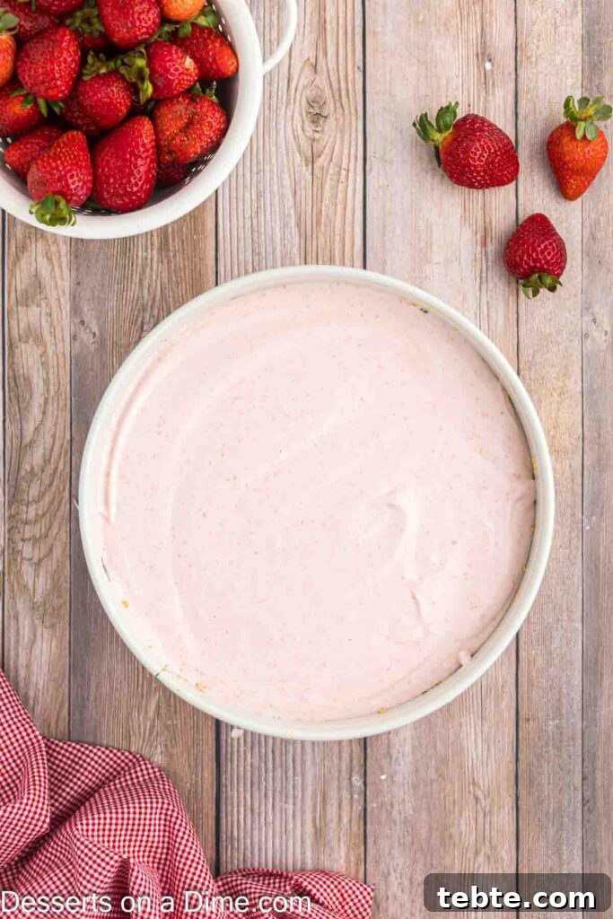 Creamy No-Bake Strawberry Cheesecake Recipe 9 Pouring cheesecake filling into the graham cracker crust