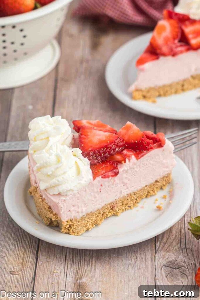 Creamy No-Bake Strawberry Cheesecake Recipe 10 Slice of strawberry cheesecake topped with sliced strawberries and whipped cream on a plate