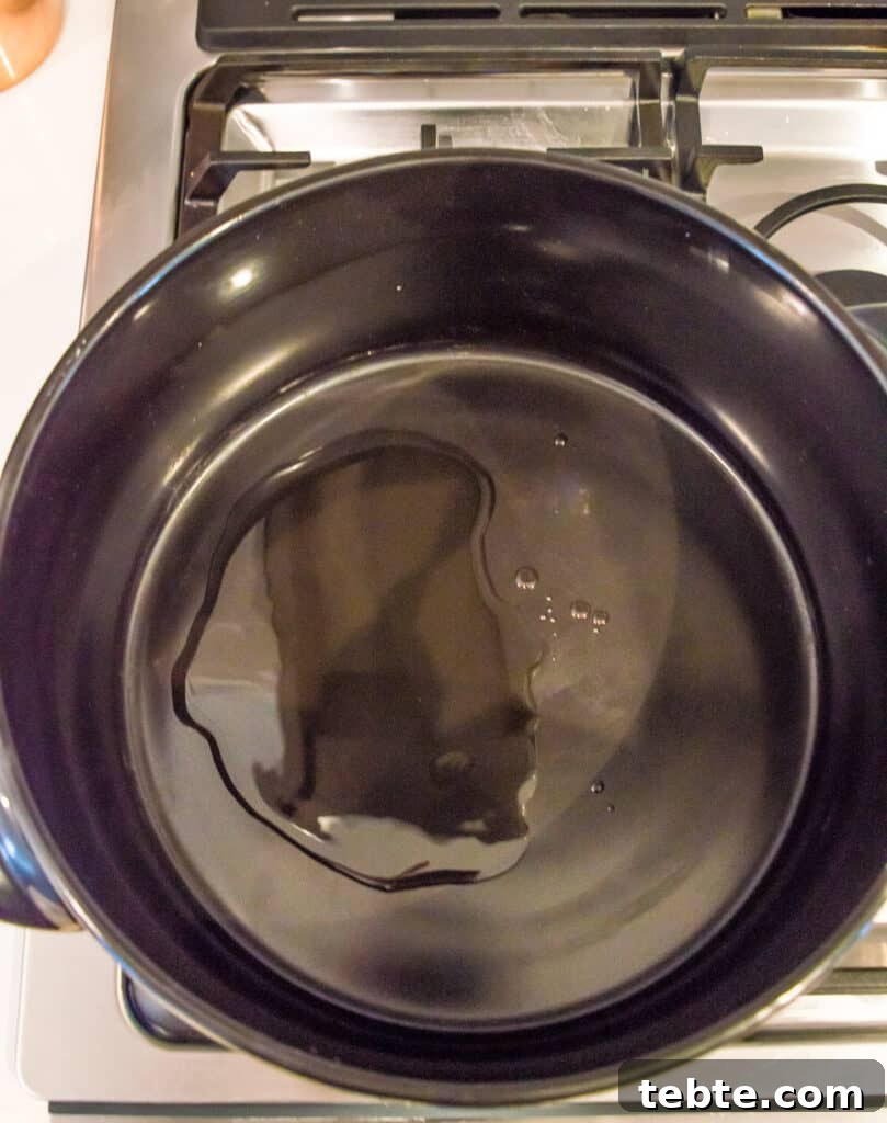 A pot on the stovetop with cooking oil in it.