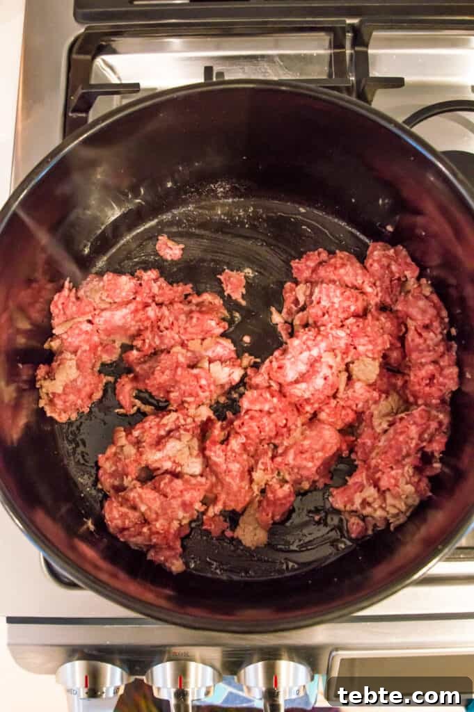 Ground pork cooking in a pot on the stovetop.