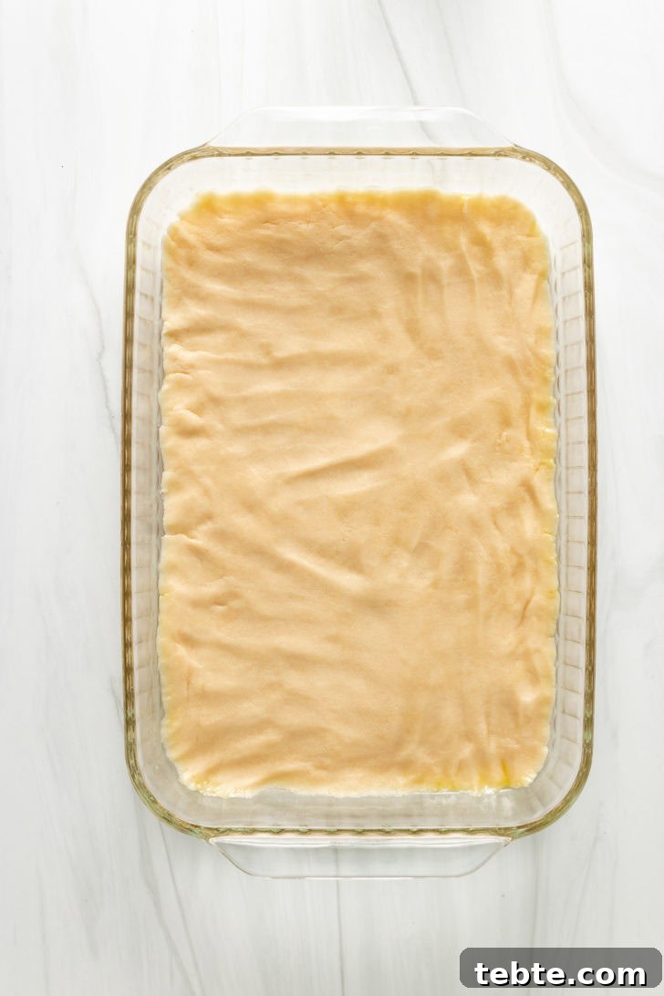 Top down view of unbaked shortbread crust in a baking dish.