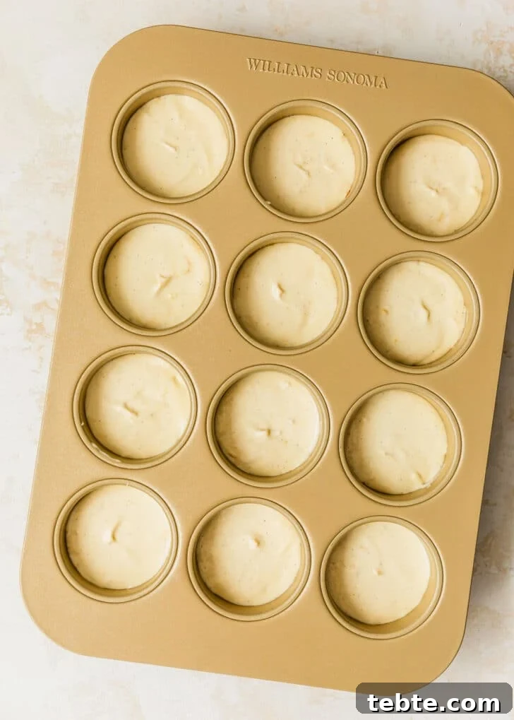 Mini Strawberry Cheesecakes Recipe: Perfect Bite-Sized Treats 13 A mini cheesecake pan of raw cheesecakes on a tan counter.