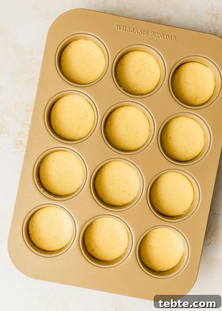 Mini Strawberry Cheesecakes Recipe: Perfect Bite-Sized Treats 14 A gold pan of mini strawberry cheesecakes on a tan counter.