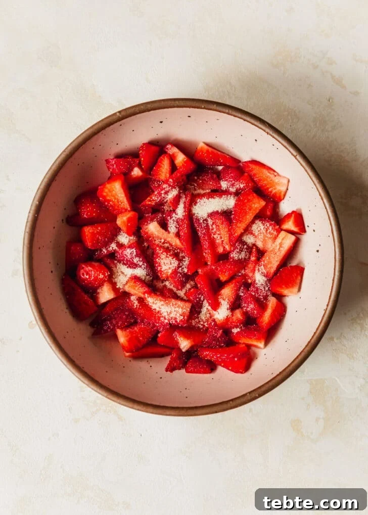 Mini Strawberry Cheesecakes Recipe: Perfect Bite-Sized Treats 15 A pink bowl of strawberries on a tan counter.