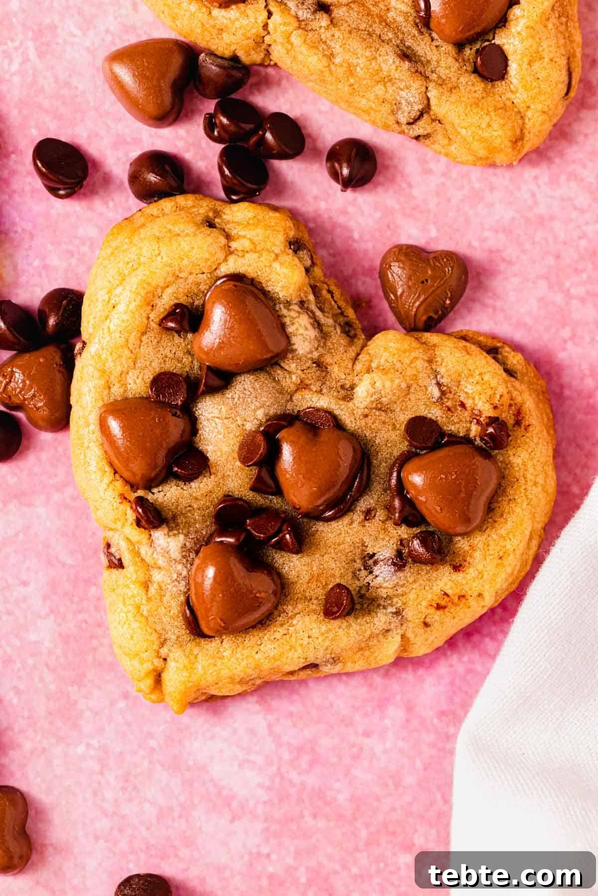 heart shaped chocolate chip cookie on counter with chocolate hearts