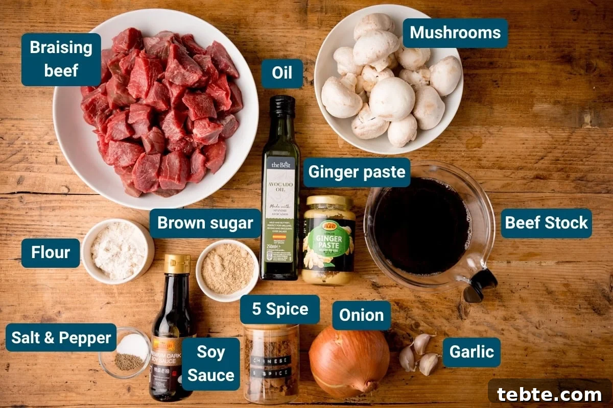 Chinese-Style Beef Curry Recipe: Savory Stir-Fry with Aromatics 4 Top-down view of ingredients for Chinese Beef curry on a wooden board, including chopped beef, mushrooms, onion, garlic, ginger paste, oil, soy sauce, flour, brown sugar, five spice, salt and pepper. Each ingredient is labelled.