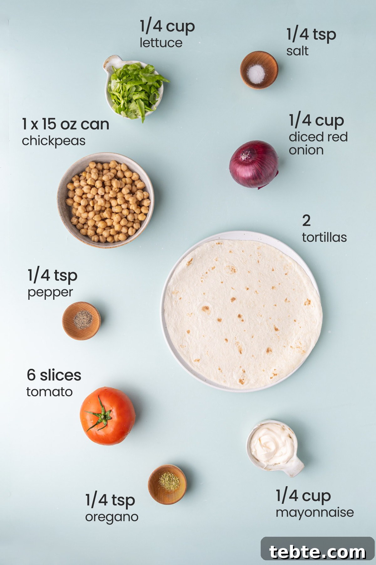 10-Minute Chickpea Salad Wrap Recipe for Quick Lunch 3 All ingredients needed for a chickpea salad wrap including lettuce, salt, red onion, chickpeas, tortillas, pepper, tomato, oregano, and mayonnaise.