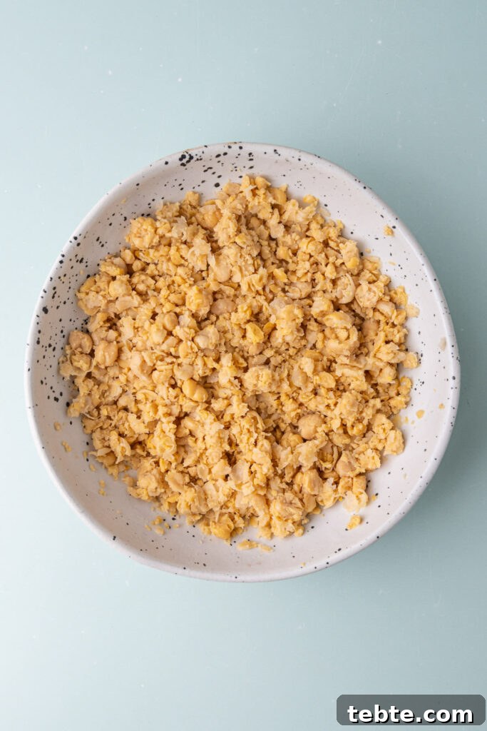 10-Minute Chickpea Salad Wrap Recipe for Quick Lunch 4 Canned chickpeas drained and smashed with a potato masher in a shallow bowl.