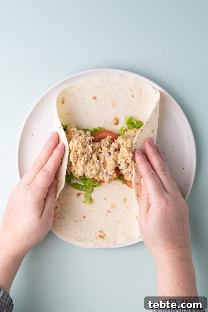 10-Minute Chickpea Salad Wrap Recipe for Quick Lunch 7 Folding both sides of tortilla over fillings to roll into a tight wrap.