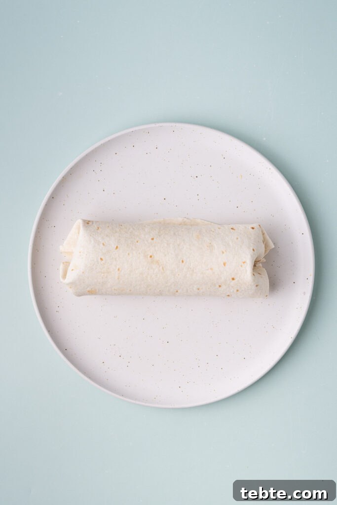 10-Minute Chickpea Salad Wrap Recipe for Quick Lunch 9 Wrap with chickpea salad rolled neatly on a plate and ready to enjoy.