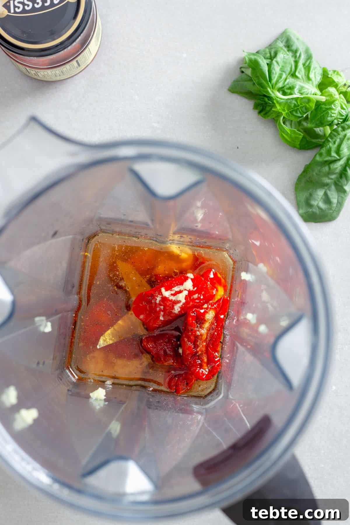 Sun-Dried Tomato Vinaigrette Recipe for Bright, Tangy Salads 5 An overhead shot of a blender with sun-dried tomatoes, oil, red wine vinegar, garlic, salt and pepper inside.