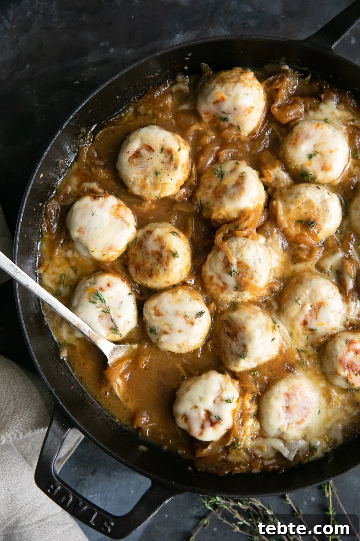 French Onion Meatball Skillet Recipe: Savory One-Pan Dinner 3 Large skillet filled with turkey meatballs simmering in a rich gravy filled with onions and covered with cheese.