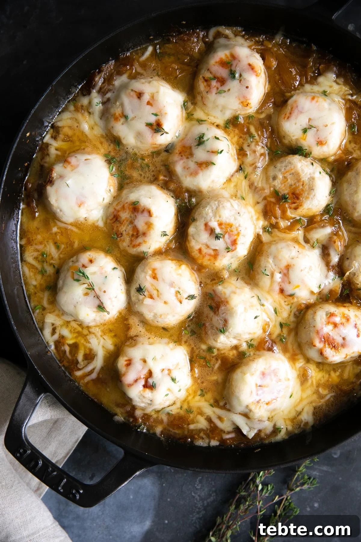 French Onion Meatball Skillet Recipe: Savory One-Pan Dinner 7 Large skillet filled with turkey meatballs simmering in a rich gravy filled with onions and covered with cheese.
