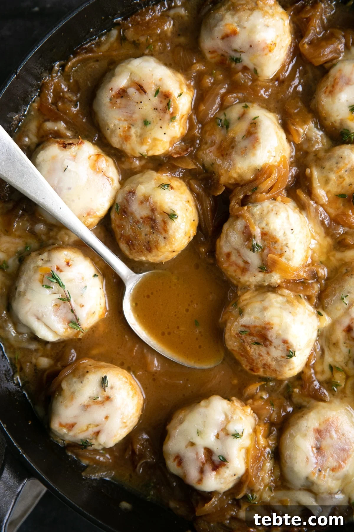 French Onion Meatball Skillet Recipe: Savory One-Pan Dinner 8 Large skillet filled with turkey meatballs simmering in a rich gravy filled with onions and covered with cheese.