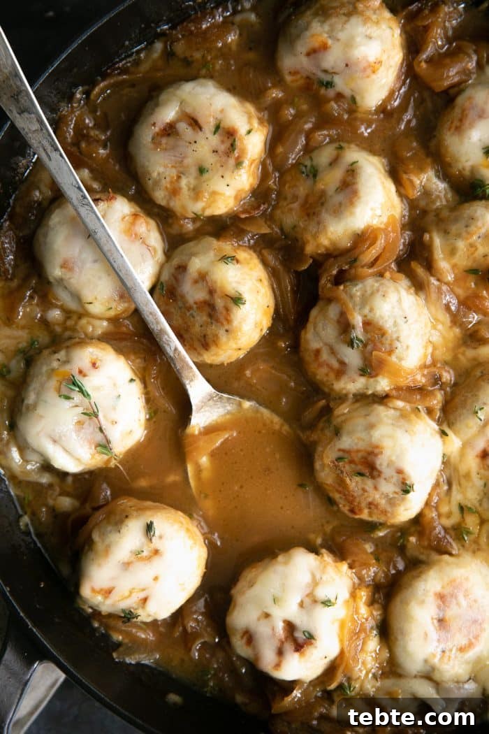French Onion Meatball Skillet Recipe: Savory One-Pan Dinner 9 Large skillet filled with turkey meatballs simmering in a rich gravy filled with onions and covered with cheese.