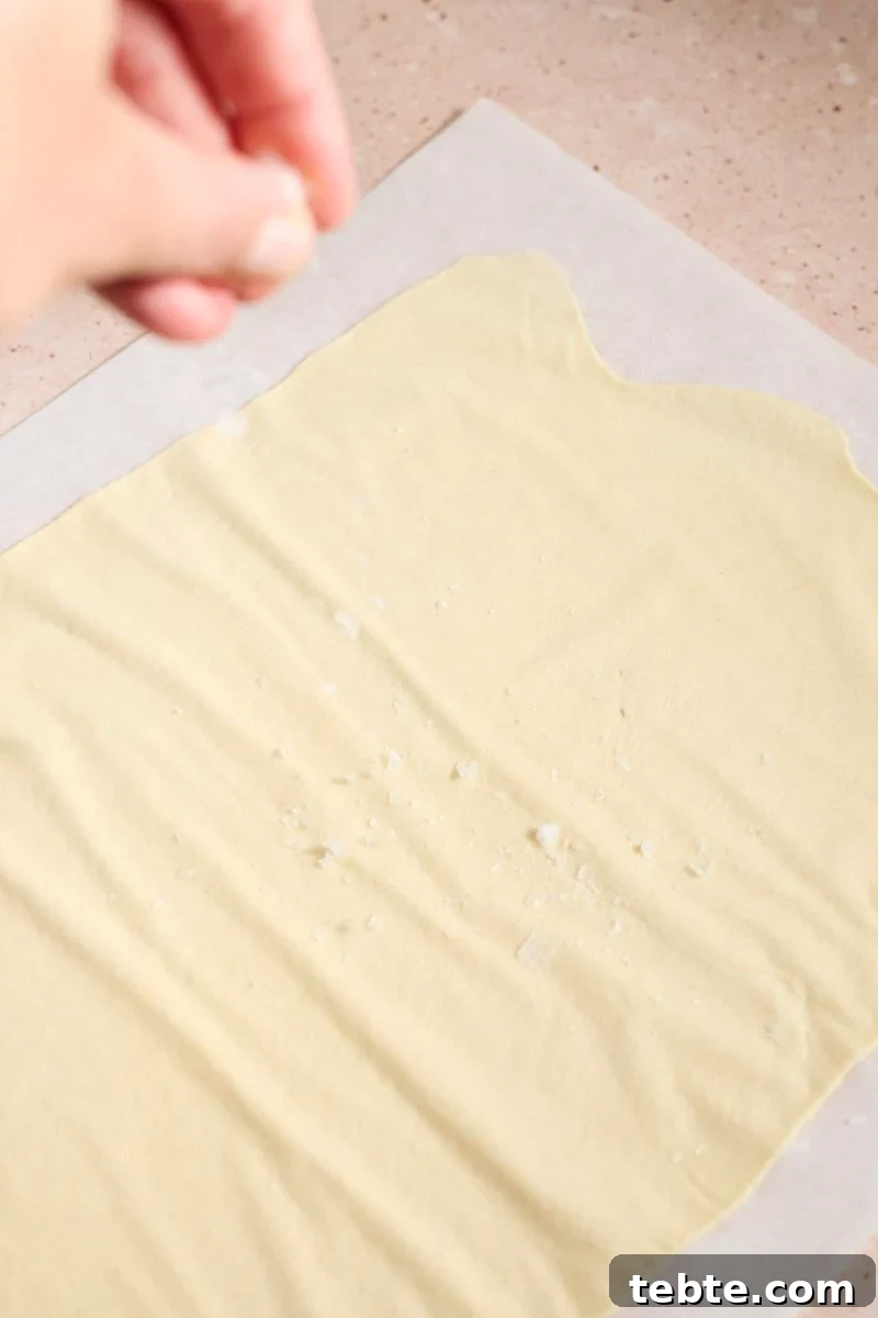 Crispy Sourdough Discard Crackers: Crunchy Homemade Recipe 8 Sprinkling salt on the cracker dough.
