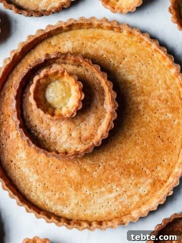 Golden brown baked tart shells in tartlet, mini and large sizes.