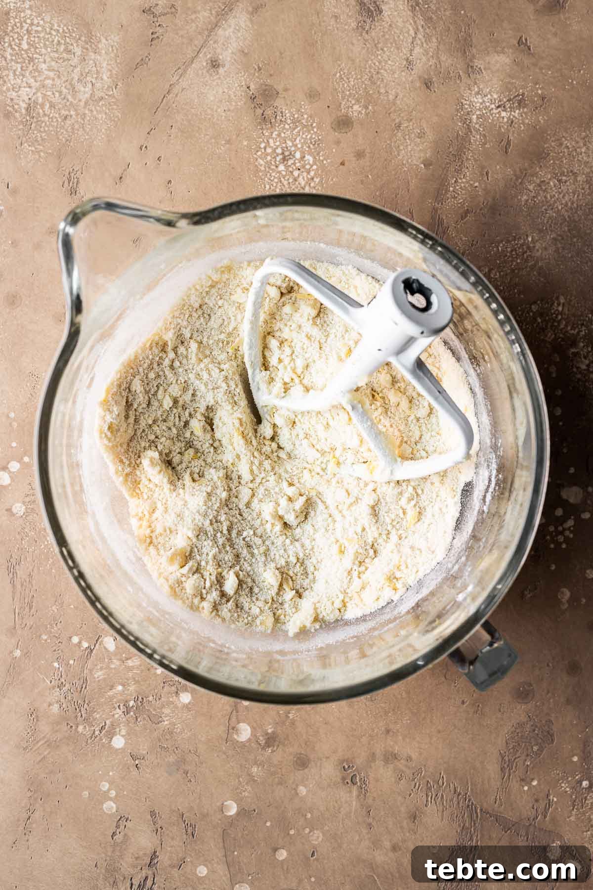 Classic Italian Jam Tart (Crostata) Recipe 5 Dry and wet ingredients for tart dough in a clear glass mixing bowl.