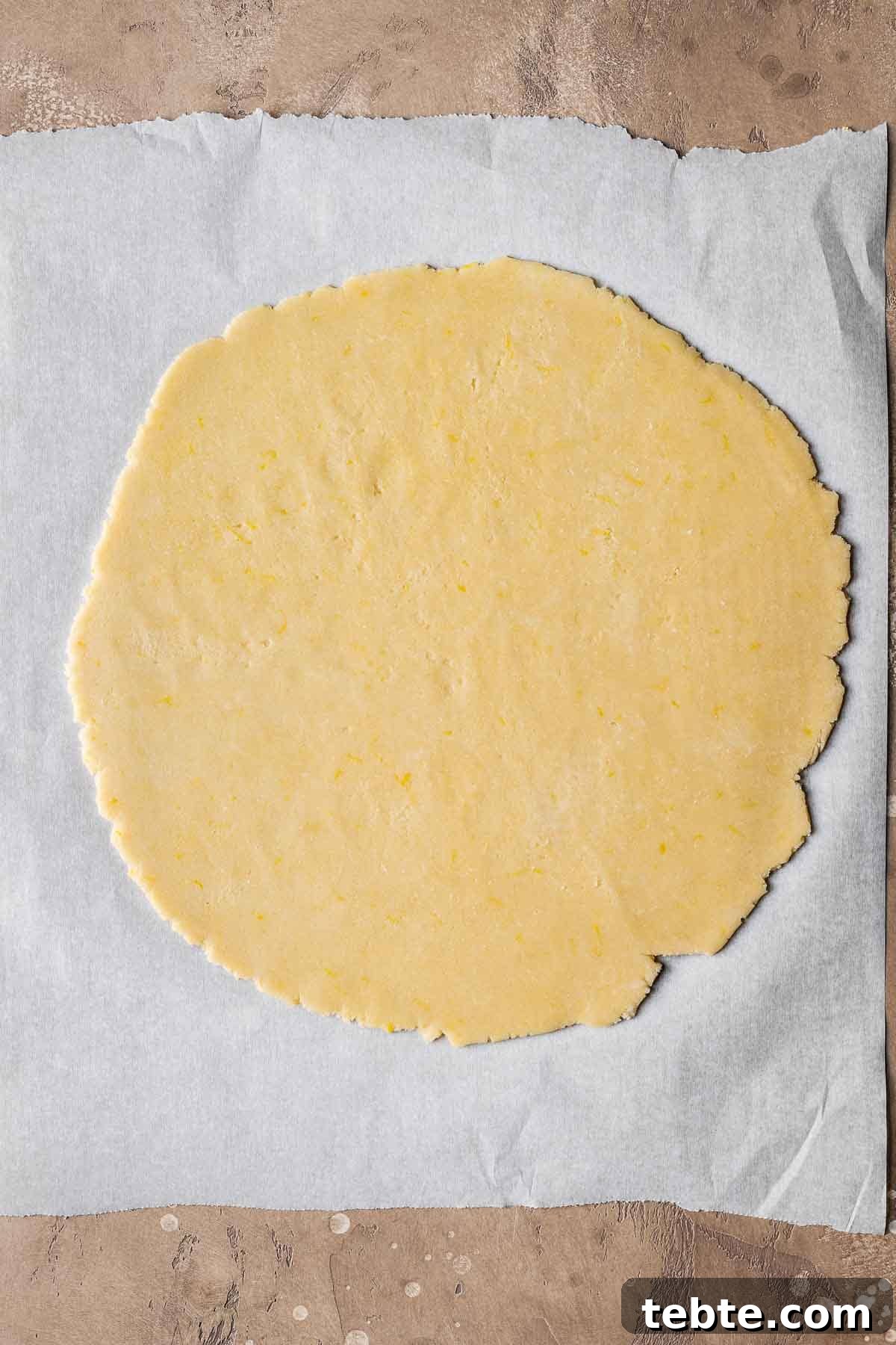 Classic Italian Jam Tart (Crostata) Recipe 8 A circle of rolled pastry dough on white parchment paper.