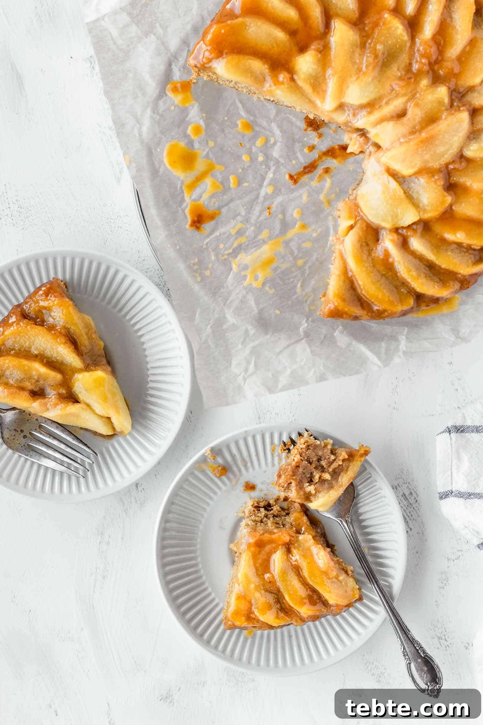 Moist Vegan Apple Cake Recipe with Cinnamon and Maple Glaze 4 Two slices of vegan apple cake on small white plates next to the whole cake.