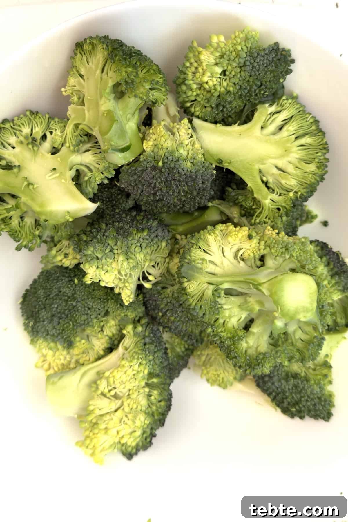 Crispy Air Fryer Broccoli Recipe in Minutes 4 air fryer broccoli cut up in a bowl and ready to be cooked